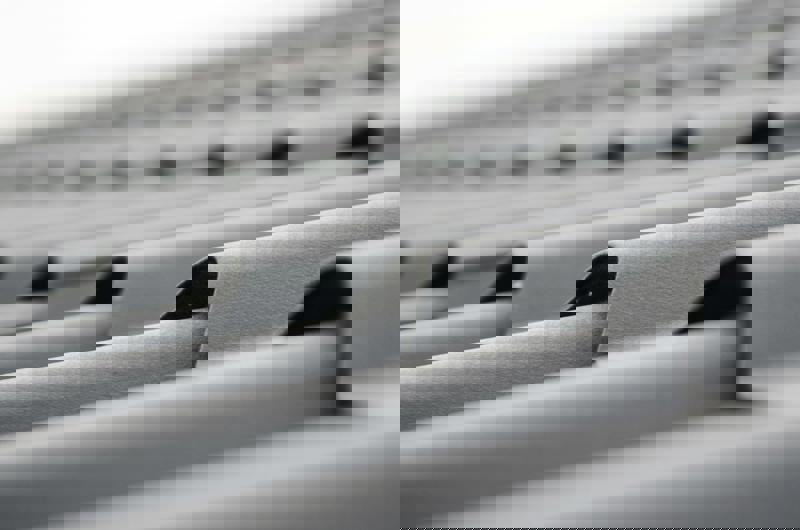 Närbild på grå takplåt med vågig profil, fotograferad i sidoperspektiv. 