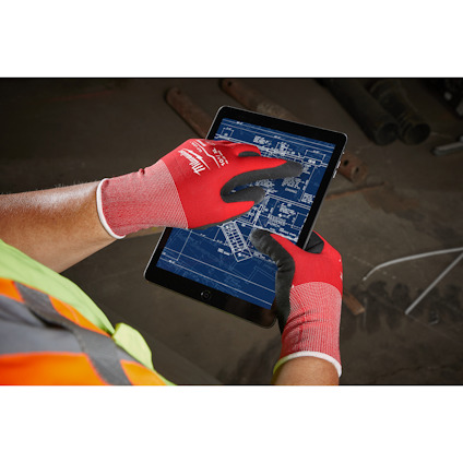 Person i röda handskar använder en surfplatta med blå ritning.