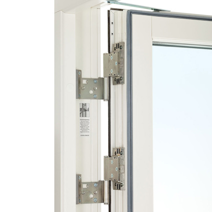 Öppen vit dörr med metallgångjärn och en svart gummitätning längs kanten.