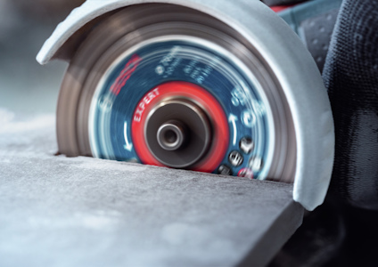 Vinkelslip med roterande skiva som skär genom stenmaterial.