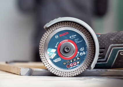 Vinkelslip med Bosch Expert kapskiva, diameter 76 mm, ligger på en träram.