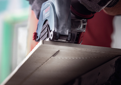 Cirkelsåg skär i träskiva, sågbladet syns i närbild.