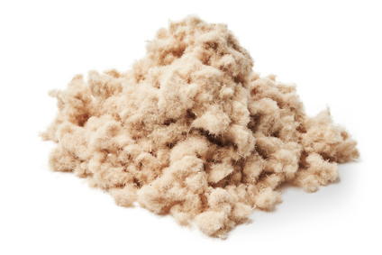 En hög med lösull i beige färg.