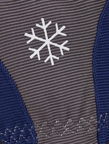 Grå och blå stickad yta med ett vitt snöflingemönster i mitten.