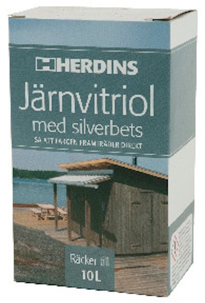 Förpackning med etikett: "HERDINS Järnvitriol med silverbets, så att färgen framträder direkt. Räcker till 10 L". Bild av en stuga vid vattnet.