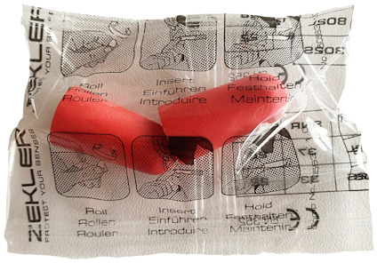 Plastpåse med tryckt instruktion för öronproppar, röd öronpropp inuti. Texter på flera språk.