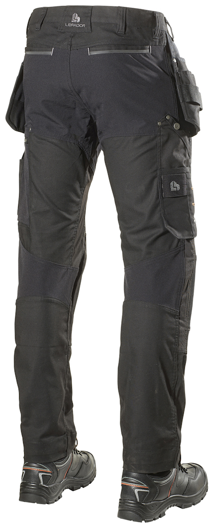 Svarta arbetsbyxor med fickor, sett bakifrån. Personen bär svarta arbetsskor.