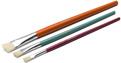 Tre platta penslar i olika storlekar med färgglada handtag i orange, teal och vinröd färg.