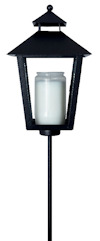 Svart lykta med spetsigt tak och glasväggar, innehåller ett vitt ljus; monterad på en smal, lång stång.