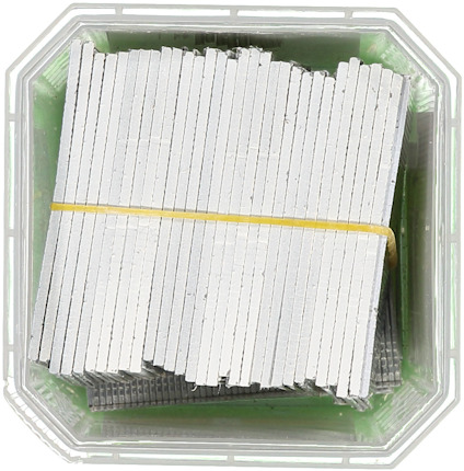 Stålklammer i en plastlåda, samlade med ett gummiband.