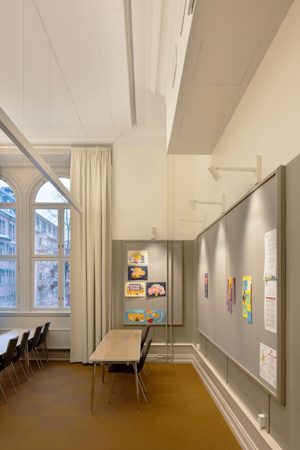 Modernt konferensrum med lång bord och stolar, stora fönster och väggdekorationer.