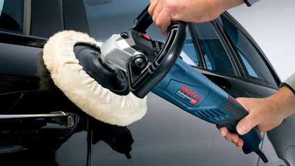 Polermaskin används för att polera en svart bil.