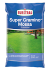 Förpackning av Substral Super Gramino Mossa gräsgödsel på blå bakgrund med en grön gräsmatta och trähus i bakgrunden.