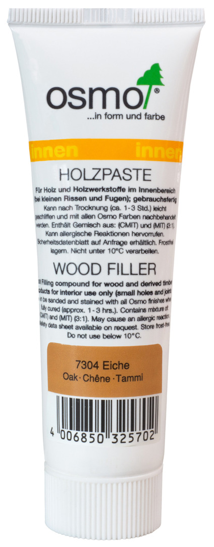 Vit tub märkt "Osmo Wood Filler 7304 Eiche Oak-Chêne-Tammi" med text på flera språk.